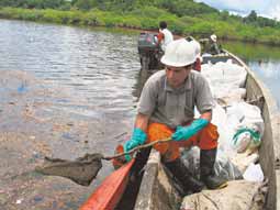 Foto El Comercio: Gonzalo Payaguaje, ind�gena siona, limpia los desechos en la laguna Caim�n Cocha